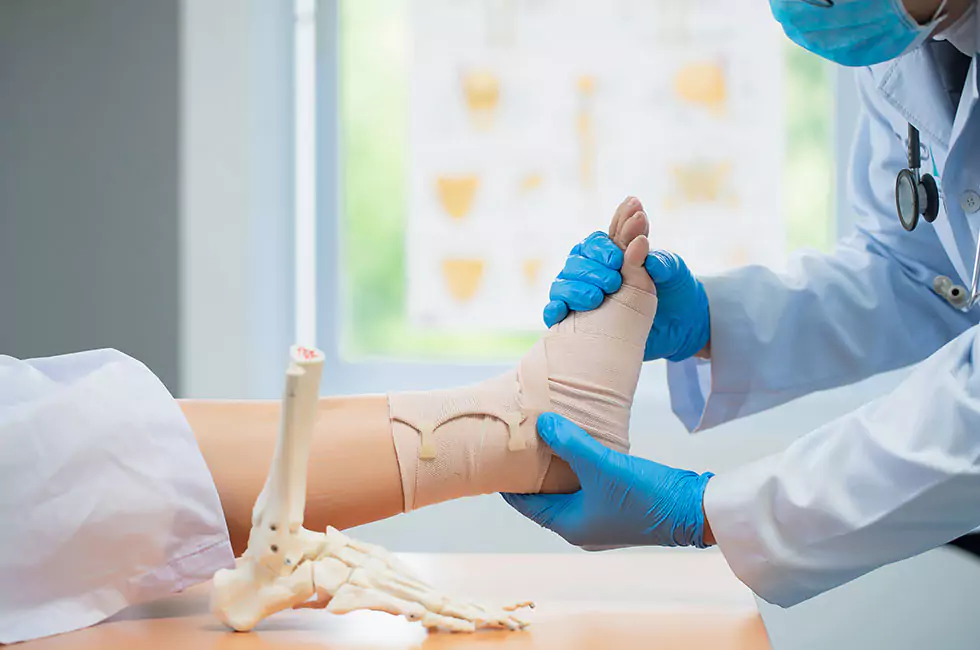 Orthopäde behandelt verletzten Fuß